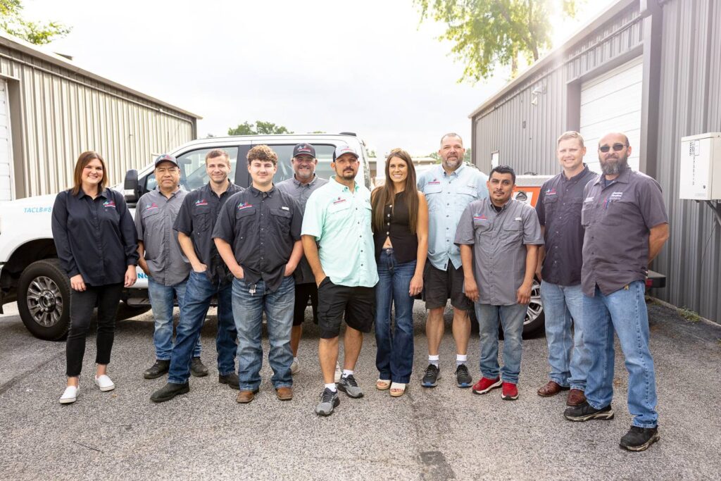 Air woodlands Team posing in front of work truck