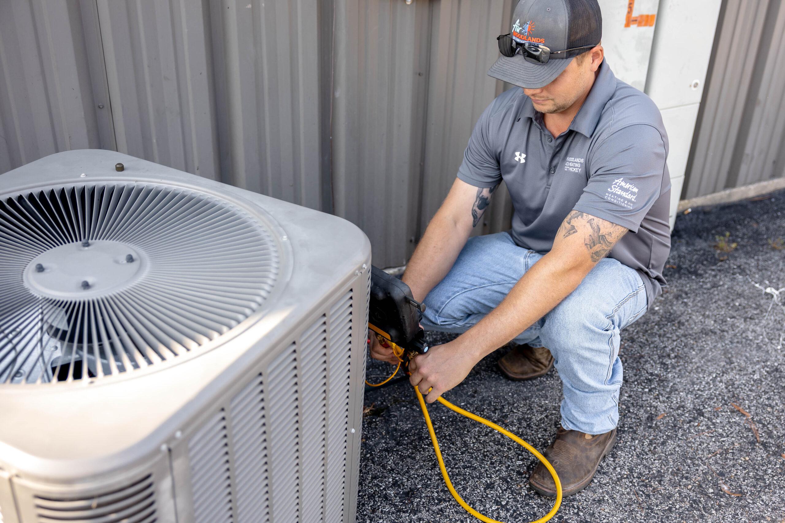 Air Woodlands technician repairing AC unit in The Woodlands TX
