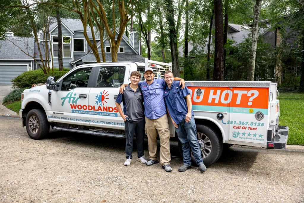 Air Woodlands owner and technicians standing in front of branded service truck in The Woodlands TX